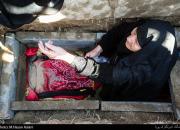 خوابیدن مادر شهید هادی طارمی در قبر فرزندش