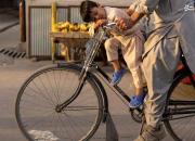 عکس/ خواب پسر روی دوچرخه پدر در کابل